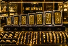 سبائك ذهب مغلفة بأوزان مختلفة داخل فاترينة عرض مع مصوغات ذهبية للاستثمار