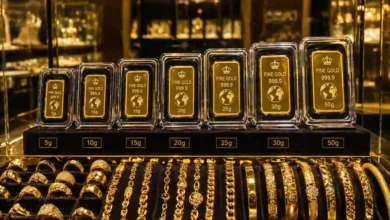 سبائك ذهب مغلفة بأوزان مختلفة داخل فاترينة عرض مع مصوغات ذهبية للاستثمار